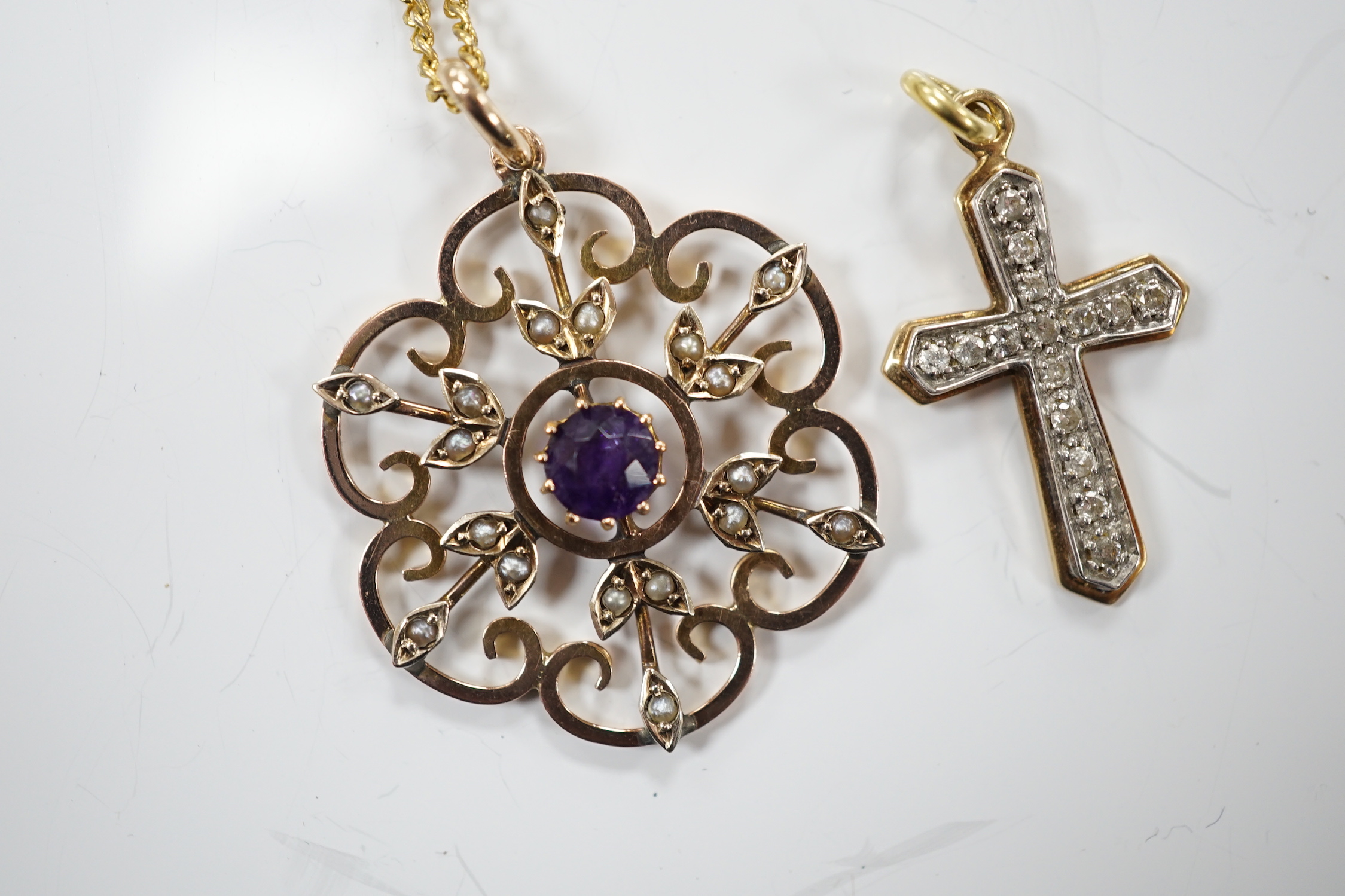 An early 20th century yellow metal, amethyst and seed pearl set pendant, 32mm, on a gilt metal chain, together with a modern yellow metal and diamond set cross pendant.